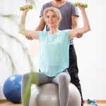 Mit hantel auf Gymnastikball